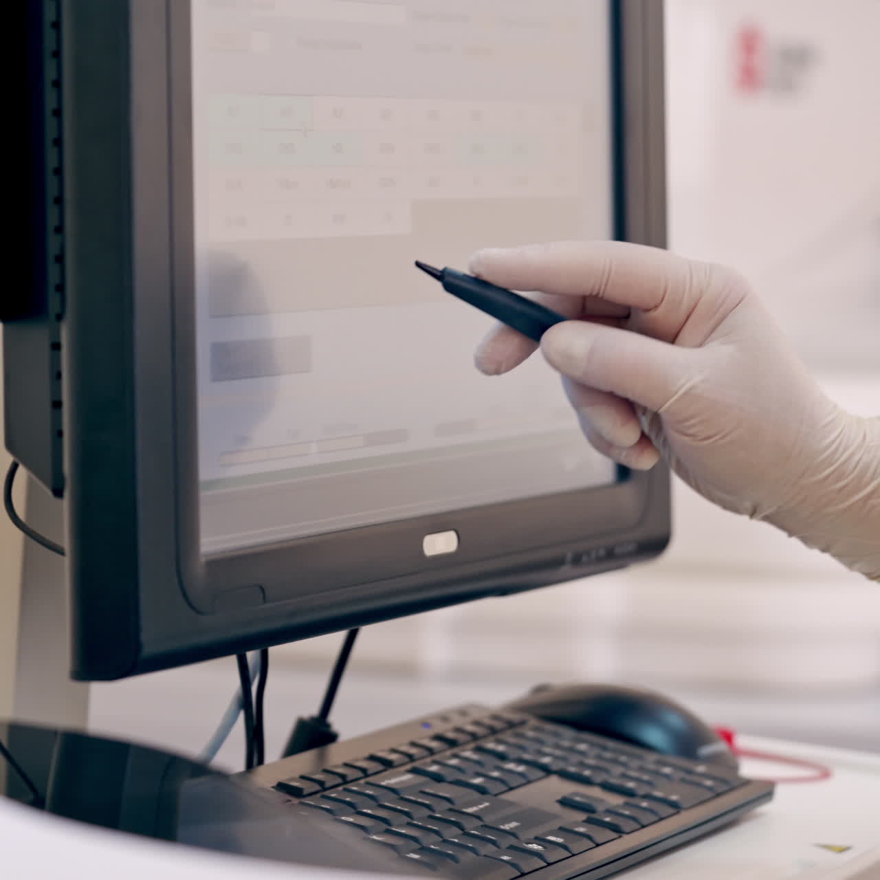 Laboratory worker uses modern device. Medical assistant holding special pen and working on a monitor in clinic. Contemporary equipment in the laboratory.