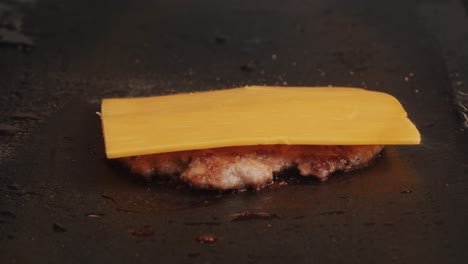 cooking american fat smash burger with cheese slice on top on grill close-up. beef or pork cutlet smashing by burger press. the chef in kitchen of the restaurant making cutlets for burgers - smash burger beefsteak. fast and street food concept.