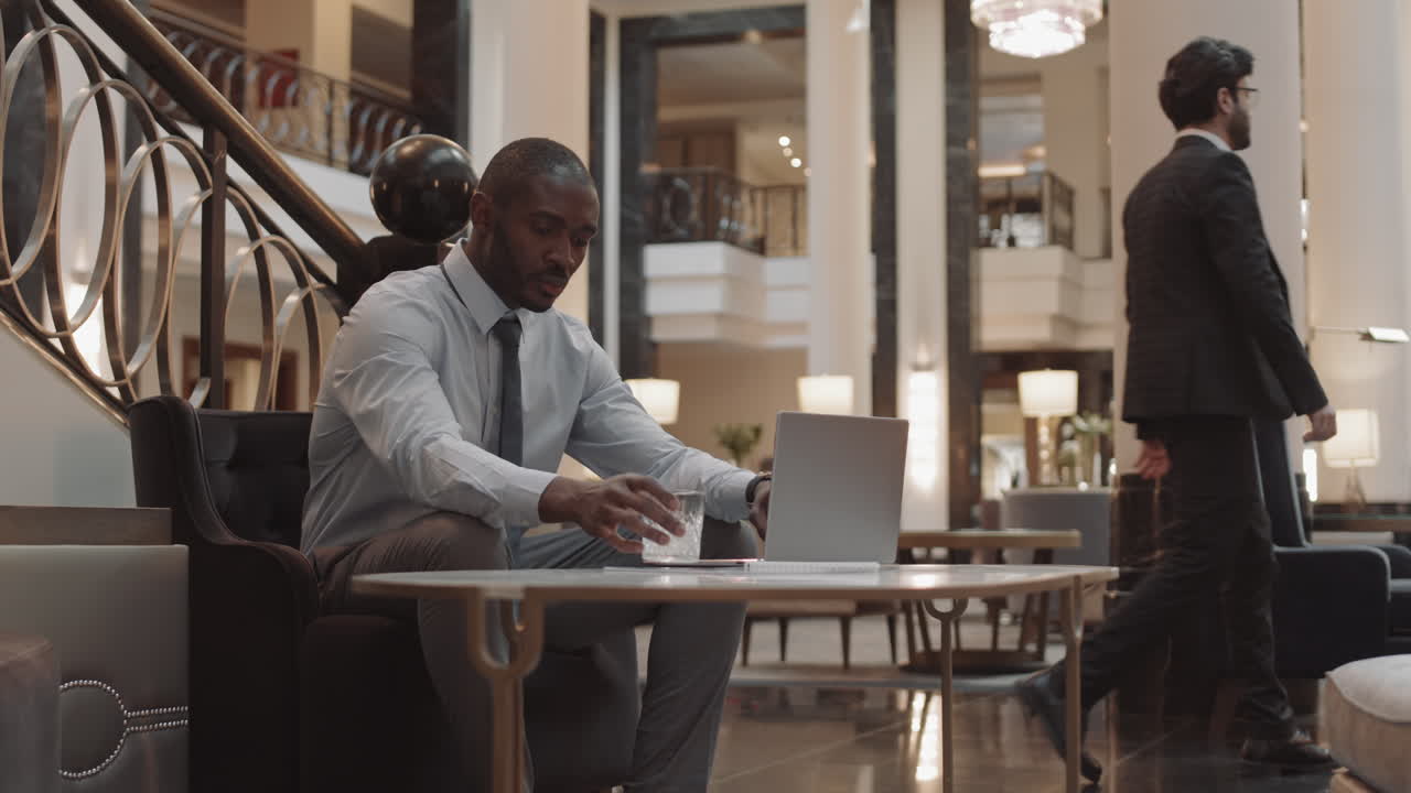 Businessman Using Computer in Lobby
