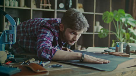 craftsman working with leather at home workshop