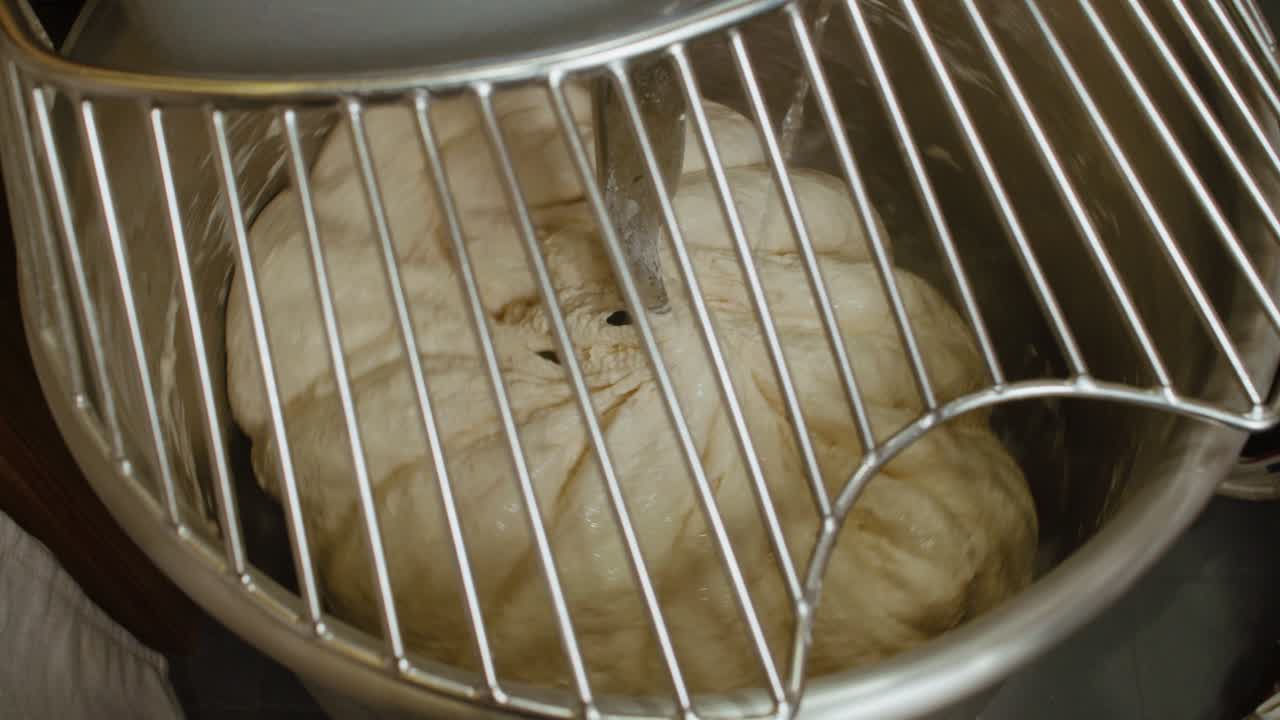 셰프는 공업용 주방 서에 차가운 물을 첨가하여 피자 반죽이 내부에 회전합니다.