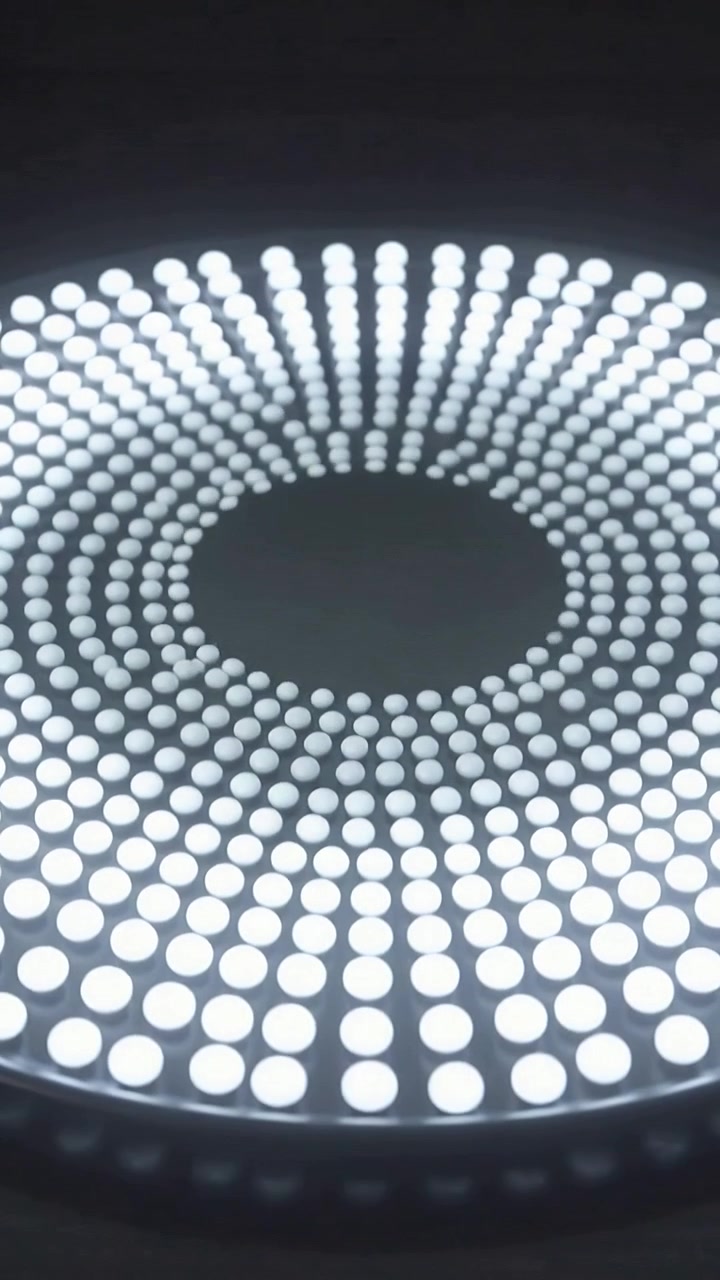 Vertical video: Tilting camera over dark round tray on set showing white dots to show central void