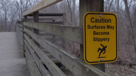 caution surfaces may become slippery sign on bridge