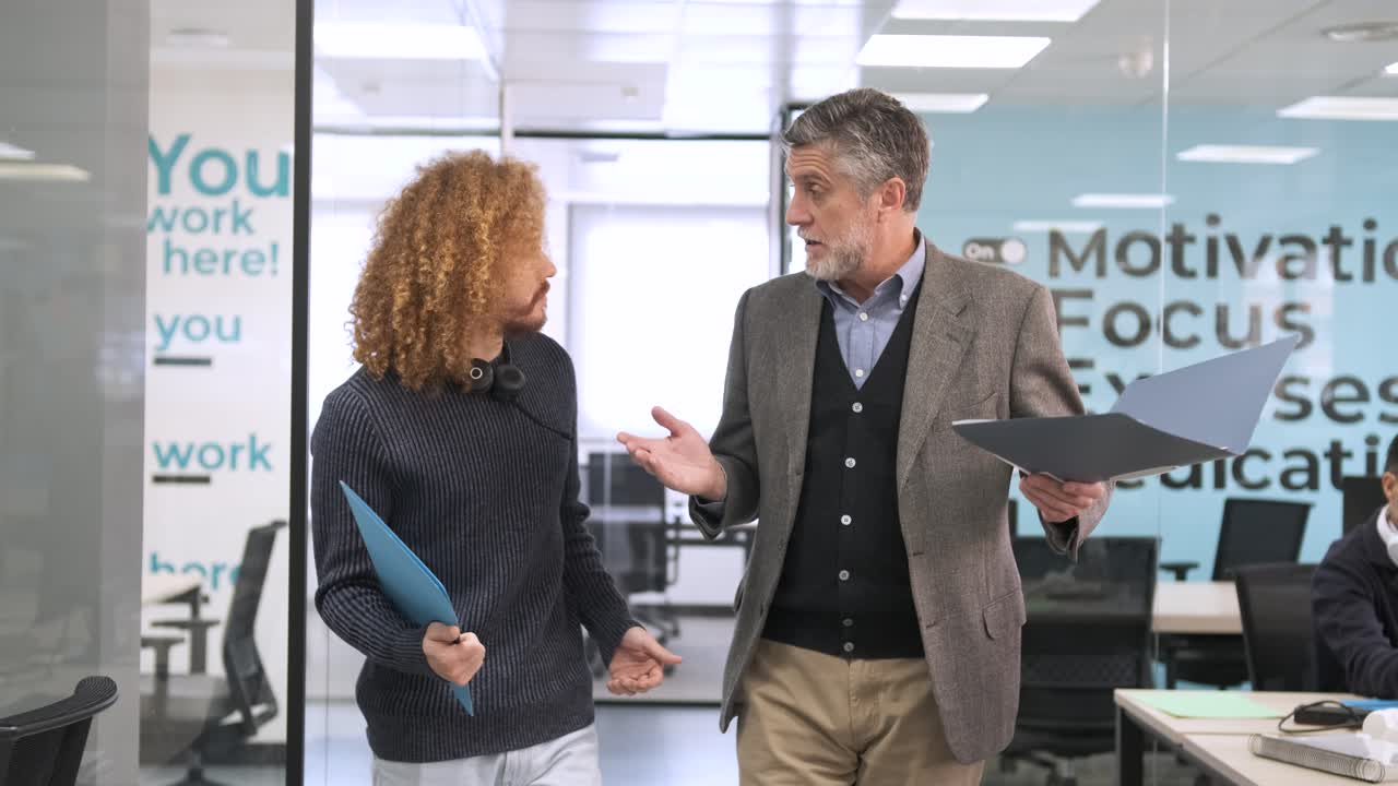 Confident manager discussing strategy with creative businessman in office