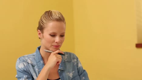 blonde student taking notes in classroom
