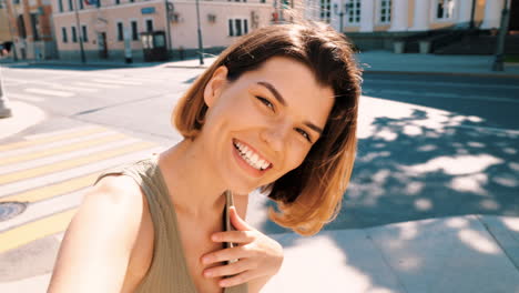 una mujer joven tomando una selfie en una calle de la ciudad