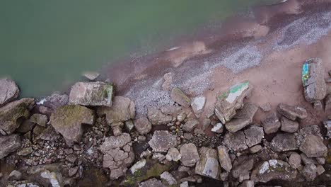 aerial birdseye view of abandoned seaside fortification building at karosta northern forts on the beach of baltic sea in liepaja in overcast spring day, drone shot moving backwards