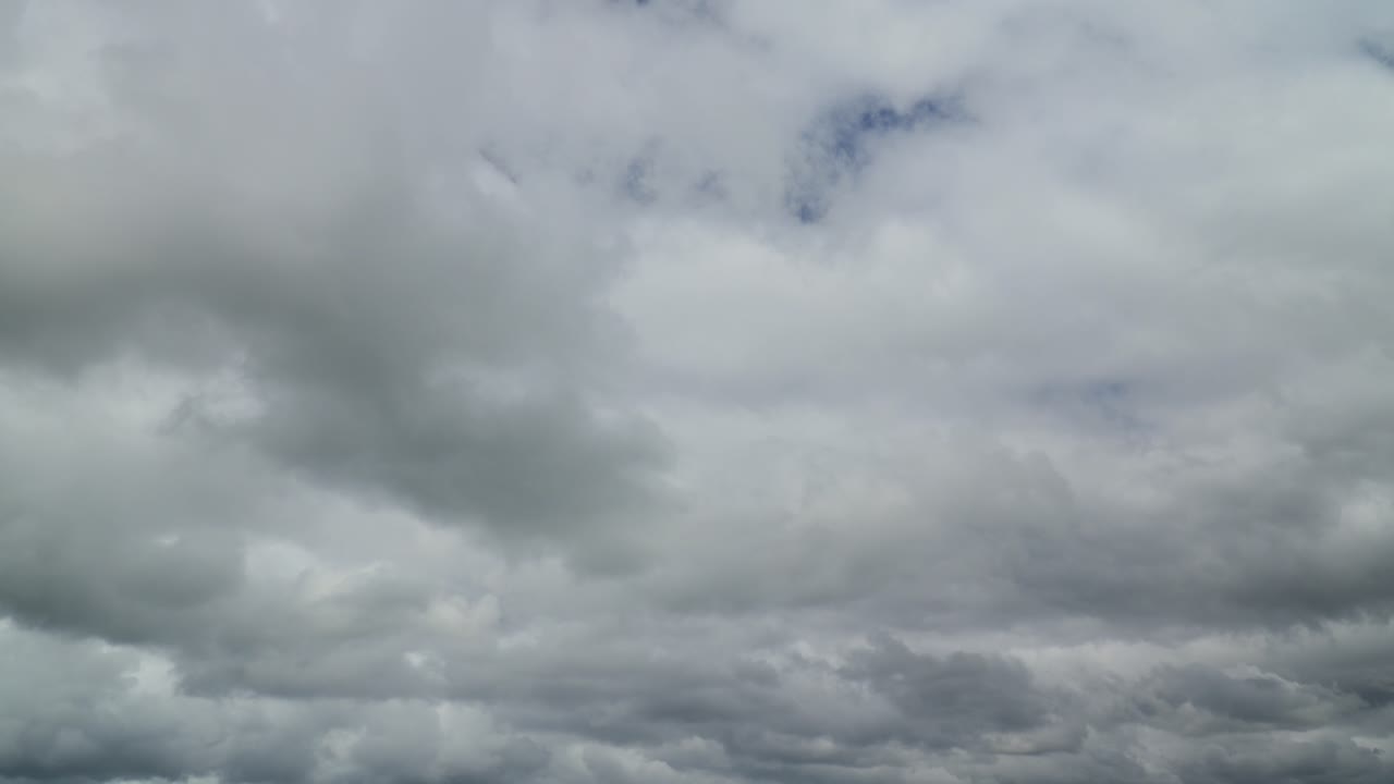 White and grey bottomed clouds rolling towards a darker cloudy horizon