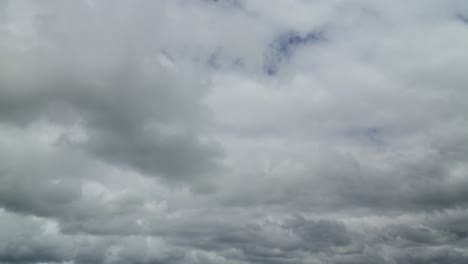 white and grey bottomed clouds rolling towards a darker cloudy horizon