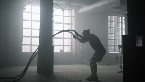 Guy-battling-ropes-during-training-session.-Sportsman-performing-intense-workout