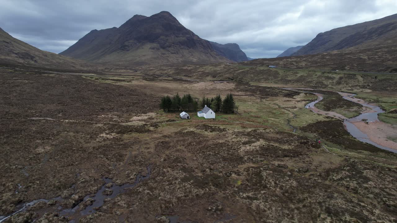 Dramatic scenes orbit view of the remote white cottage in the Glencoe highlands of Scotland.