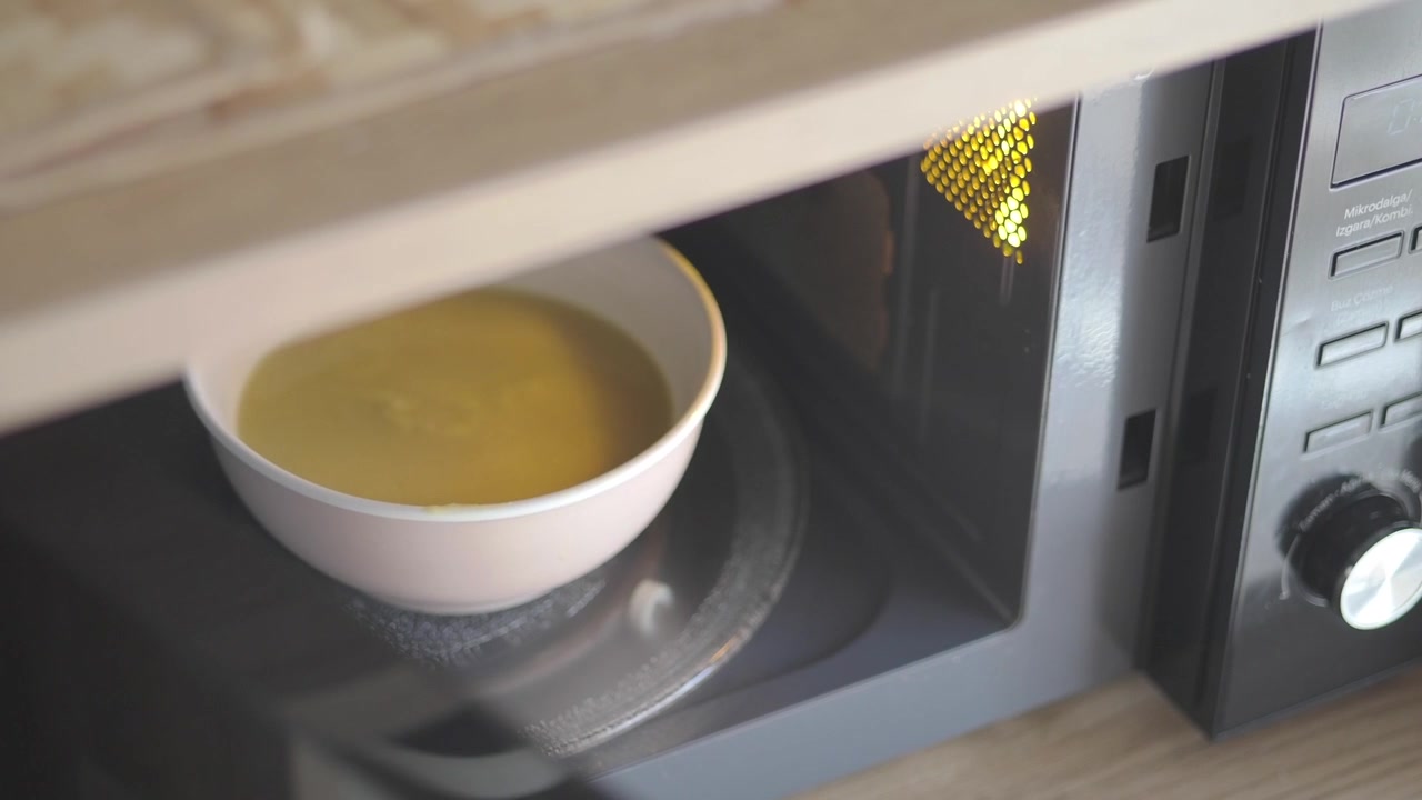 Ciotola di zuppa che ruota all'interno di un forno a microonde