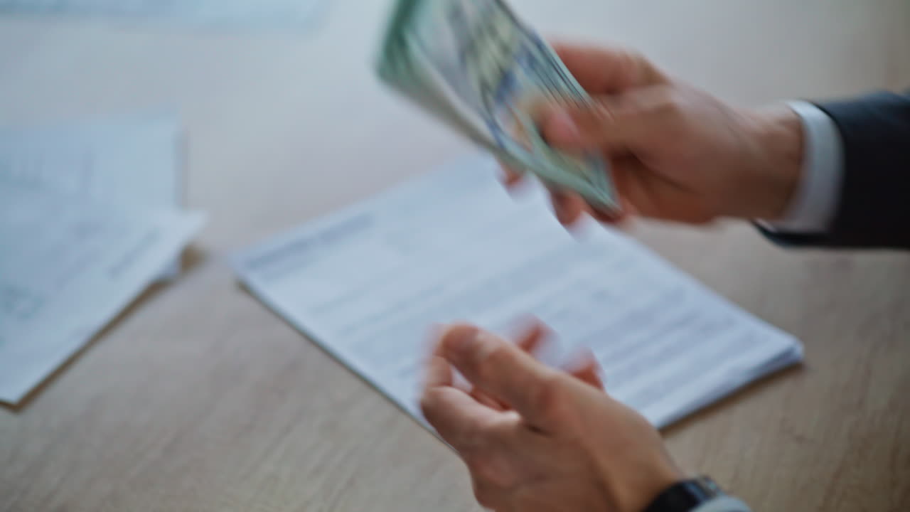 Primer plano de unas manos contando dinero en una oficina de lujo. Empresario entregando dólares