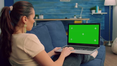 retrato de una mujer caucásica escribiendo y mirando una computadora portátil