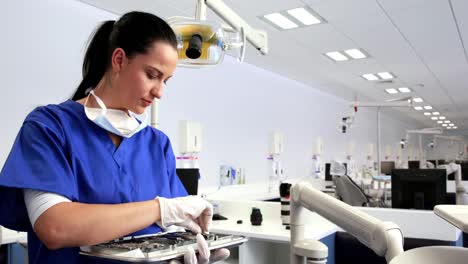 Dentist-preparing-her-tools-and-smiling-at-camera