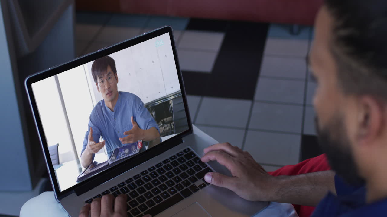 Middle eastern man having a video call with male office colleague on laptop