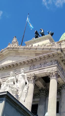 national congress, sculptures, argentine flag waves at buenos aires daylight sky