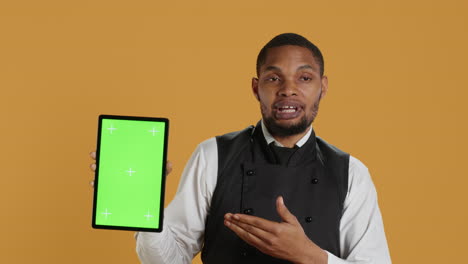 Waiter-showing-a-tablet-with-isolated-copy-space-in-studio