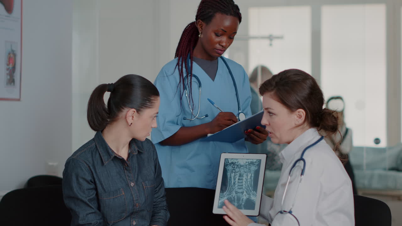 Close up of multi ethnic team explaining x ray diagnosis on tablet