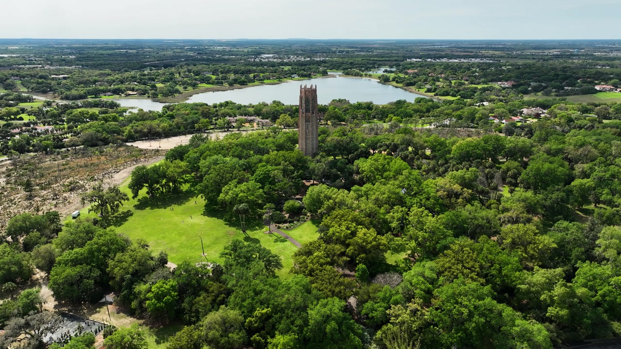 A high-angle aerial highlights Bok Tower Gardens, with the historic Singing Tower standing tall above tropical foliage.