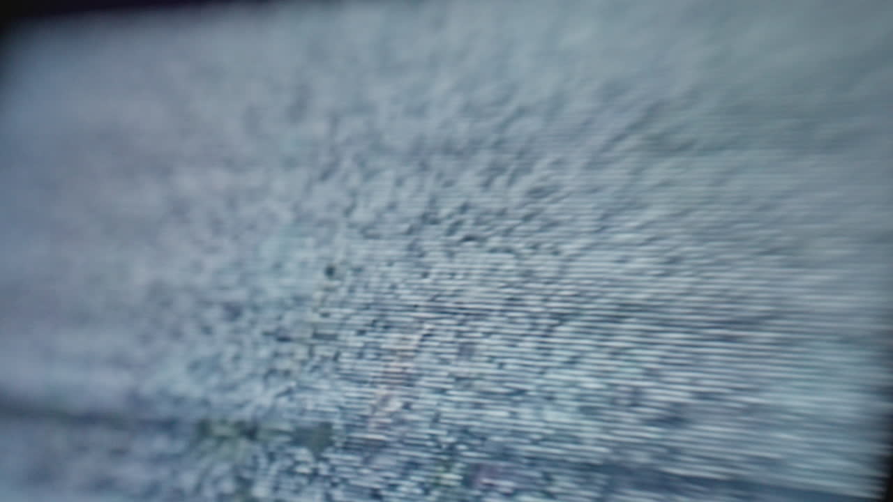 디지털 컴퓨터 장치 화면의 극단적인 클로즈업으로 걱거리는 정적 노이즈 신호를 표시합니다.