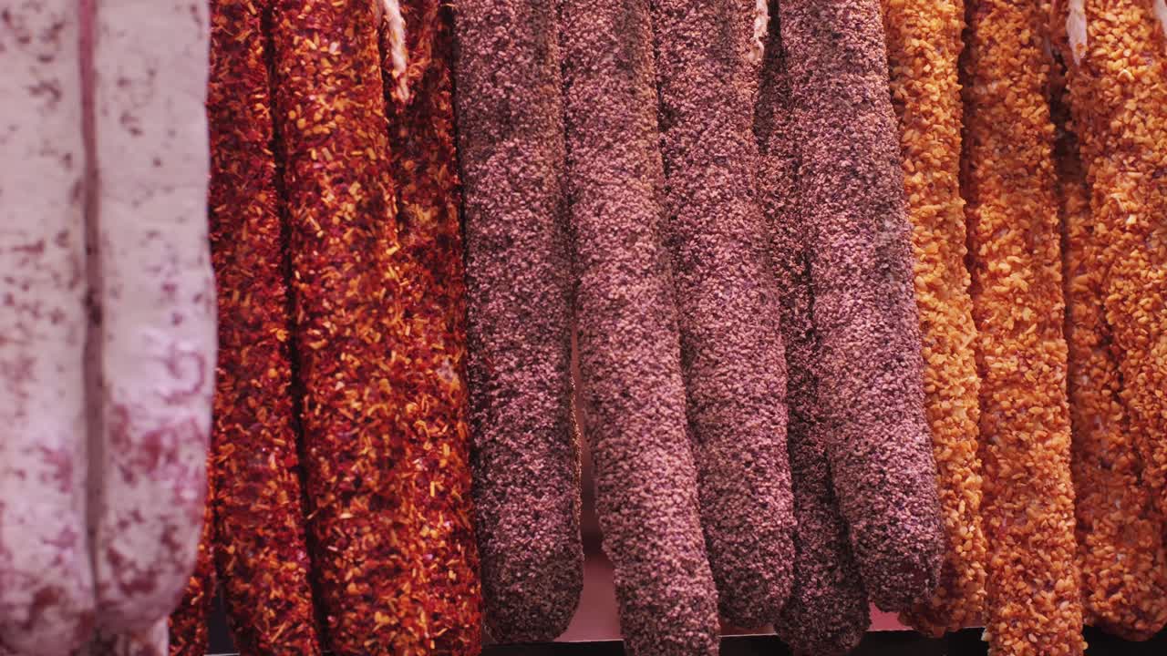 At a traditional market, a colorful variety of spicy sausages is displayed, each showcasing delicious flavors