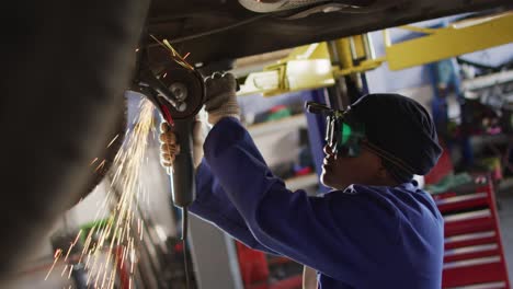 Video-of-african-american-female-car-mechanic-using-grinder