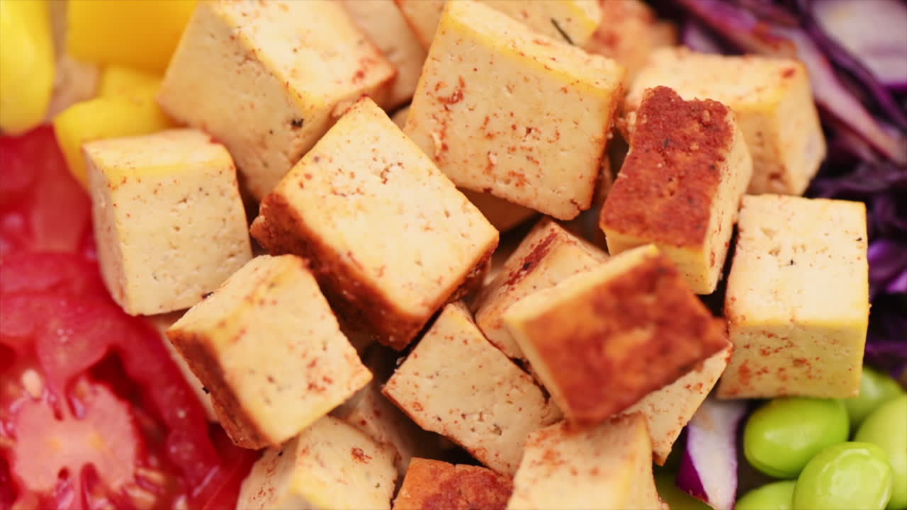 Primer plano de un poke vegano con verduras y tofu en un bol