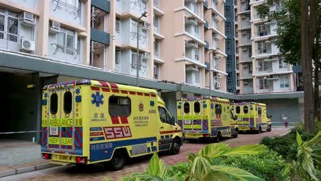 se ven ambulancias estacionadas afuera de un edificio cerrado en un complejo de viviendas públicas después de que una gran cantidad de residentes dieron positivo