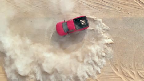 Truck-making-doughnuts-on-the-sand,-top-down-view