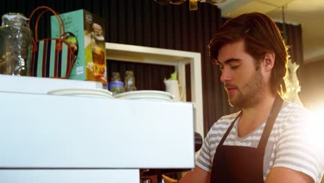 camarero usando la máquina de café