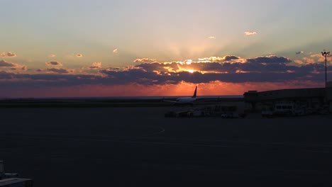 Ein-Wolkiger-Sonnenuntergangsblick-Von-Einem-Flughafen-In-Der-Nähe-Der-Flugzeuge