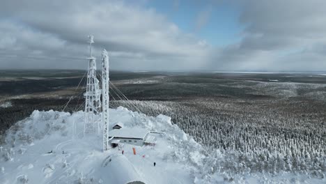 frozen mountaintop communication tower with snowy landscape