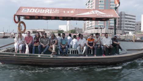 travelling on a taxi boat in deira creek, looking at another one packed with tourists. exterior day.