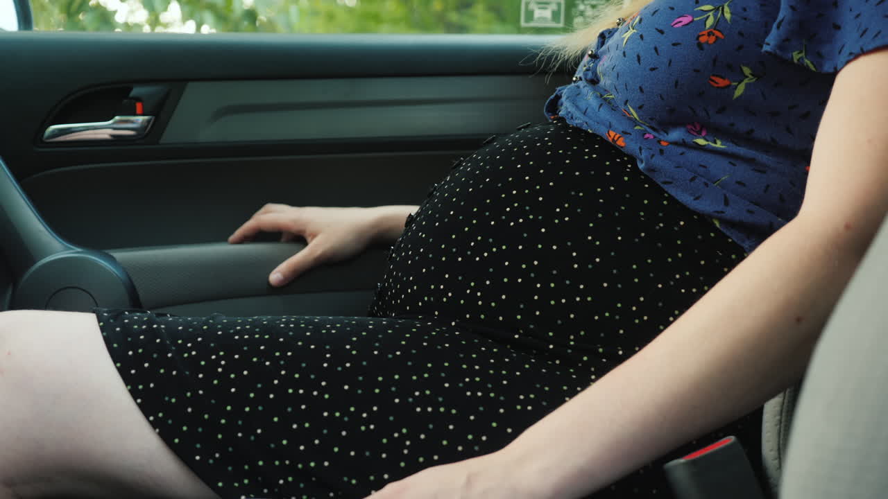 mujer embarazada irreconocible en el cinturón de seguridad del automóvil de pasajeros