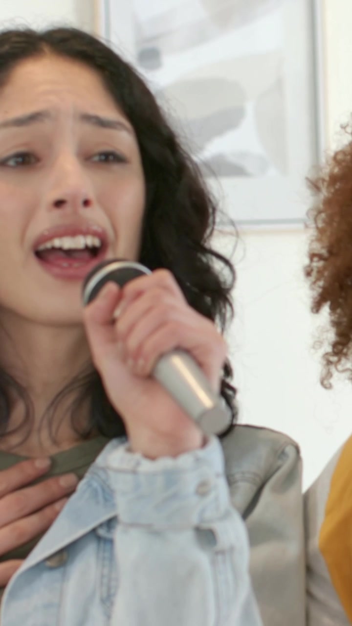 Vertical video: Song starting driving woman in denim jacket singing into mic at home rehearsing