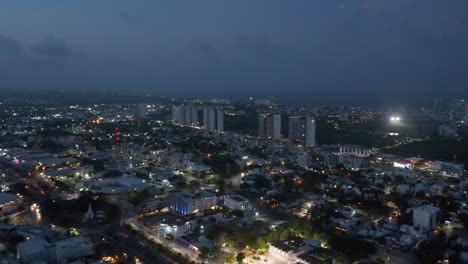 Panoramaaufnahmen-Aus-Der-Luft-Von-Stadtvierteln-Bei-Nacht.-Hohe-Moderne-Gebäude-Im-Apartmentkomplex-Im-Hintergrund.-Cancun,-Mexico