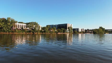Aerial Dolly-In of Fox River Towards Scenic Waterfront Apartment Buildings, Appleton, Wisconsin