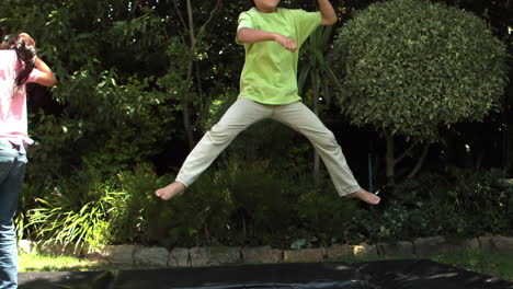 happy siblings jumping on trampoline