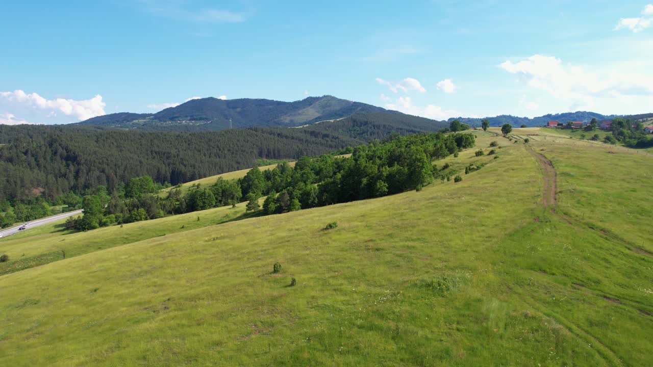 Zlatibor Mountain, Serbia. Flying Above Green Meadows With Road and Forest on Hills, Drone Shot