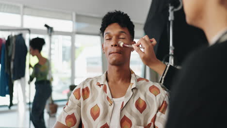 man getting makeup applied in studio