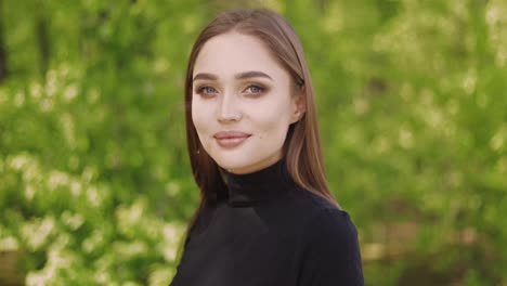 portrait of young female in black shirt and with long hair looking at camera