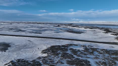 冬天在冰島雪地路上徒步旅行的人 - 空中