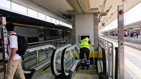 various individuals using an escalator at a train station