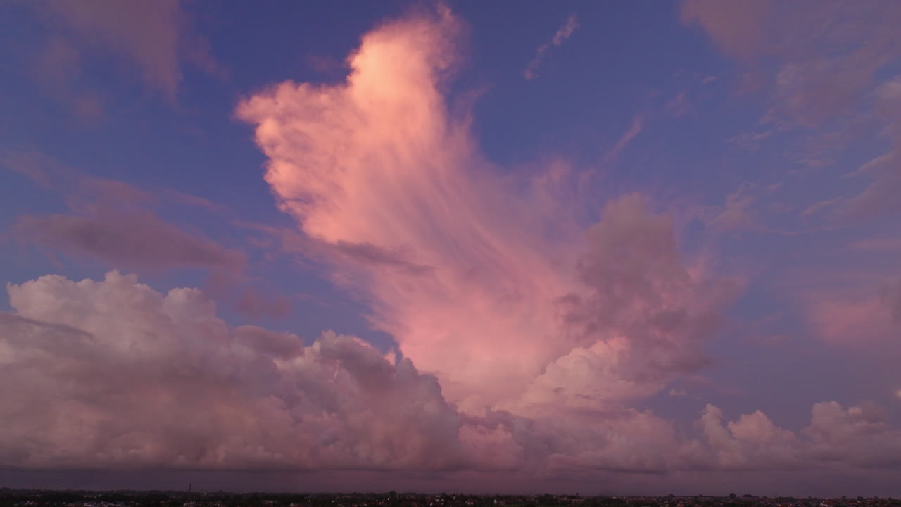 una tenue llamarada de rosa rojo hora dorada brilla en la nube sobre el cielo púrpura puesta de sol