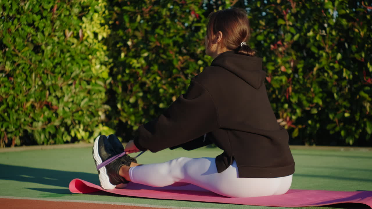 mujer haciendo ejercicio de banda de resistencia al aire libre