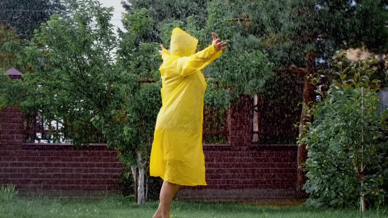 Woman enjoying a rainy day in a yellow raincoat