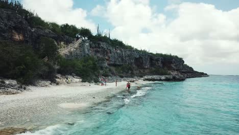 Close-up-drone-view-of-a-group-of-friends-playing-on-the-beach-in-Bonaire,-in-the-dutch-caribbean,-south-america