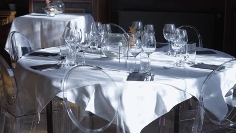 sunlit slow motion shot of a well-set fine dining table with white cloth