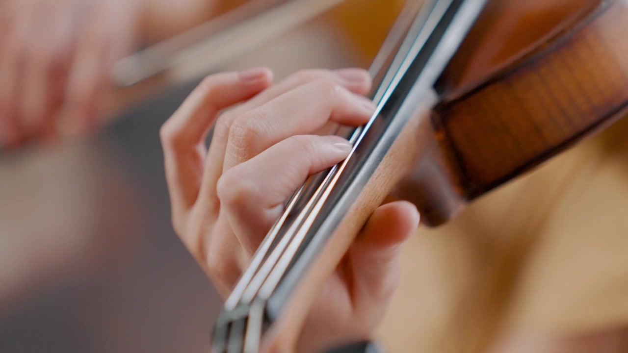 Close Up of Musician's Hand Playing Violin Strings